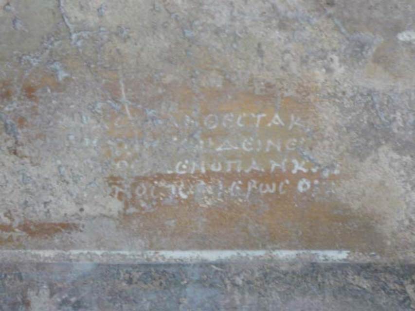 V.1.18 Pompeii. May 2012. West wall of exedra “y”, showing detail of Greek verse.  
Photo courtesy of Buzz Ferebee.