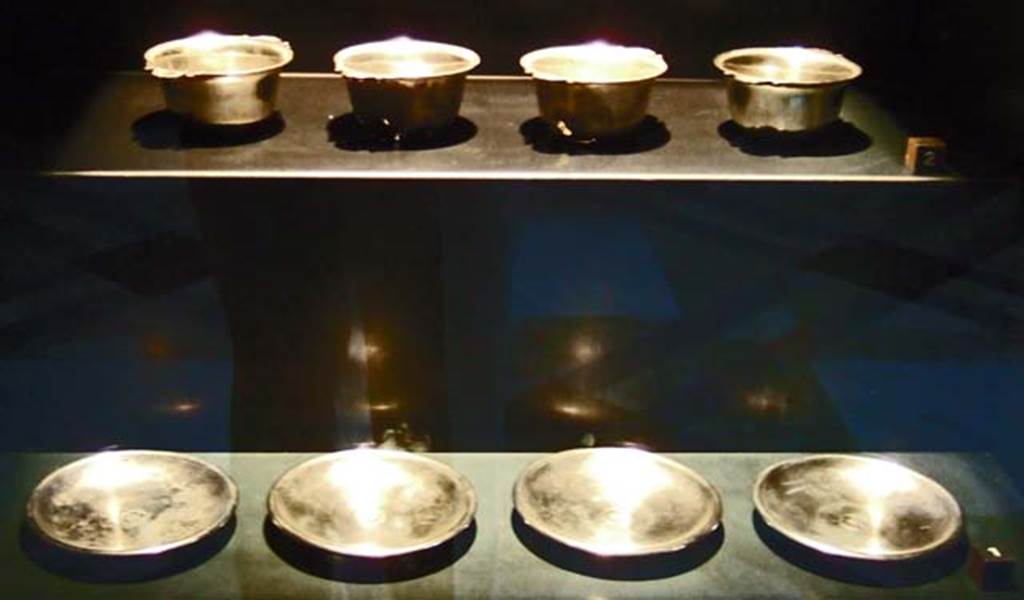 V.1.18 Pompeii. Set of four silver plates and cups. Found in the ala “e”. 
Now in Naples Archaeological Museum.
Four silver cups with short conical bodies. Inventory numbers 110846, 110847, 110848, 110849.
Four silver plates with 5 petal rosettes in the centre. Inventory numbers 110842, 110843, 110844, 110845.