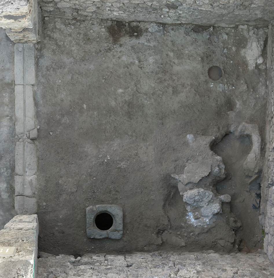 V.1.19 Pompeii. c.2005-2008. Looking down onto flooring with cistern mouth near south wall. 
Photo by Hans Thorwid.
According to Boman –
“The floor has collapsed in the SE corner, though the reason is not known: presumably a cistern or pozzo nero that has collapsed — the structure in the SE corner has not been investigated.
In the centre eastern area of the room a pozzo nero partly filled in was excavated - the material gave that the taberna could have been used as a fullers.”
Photo and words courtesy of The Swedish Pompeii Project.