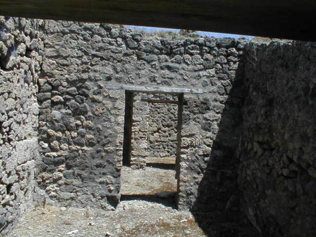 V.1.20 Pompeii. May 2005. Doorway from rear room, towards kitchen, small garden and cubiculum. According to Jashemski -  “The tiny garden (a) excavated in 1875, in the rear north-east corner of this small shop-house wedged in between 2 large houses was little more than a light well enclosed by a low wall with a gutter at the base; along the inside of the gutter, according to Viola, there was a narrow planting bed.  The kitchen (b) opened onto the garden."
See Mau, Bdl (1877), p.18
See Viola, Gli Scavi di Pompei dal 1873 al 1878, p.28.
See Jashemski, W. F., 1993. The Gardens of Pompeii, Volume II: Appendices. New York: Caratzas. (p.108)