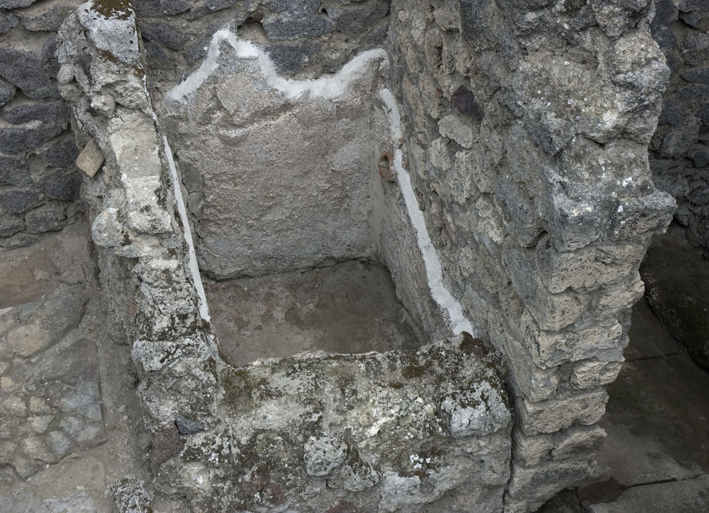 V.1.23 Pompeii. 
Room “n”, water basin (?) on east side of hearth, against north wall of kitchen area. Photo by Hans Thorwid.
Photo courtesy of the Swedish Pompeii Project.
