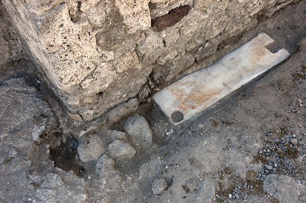 V.1.23 Pompeii. South wall at east end of entrance corridor/fauces “a”. Photo by Hans Thorwid.
“To the south it stops c. 10 cm north of the south wall in the fauces: there, in front of the south wall there is a travertine threshold, located in front of the south wall, dimensions 0.77 x 0.22 m.”
Photo and words courtesy of the Swedish Pompeii Project.