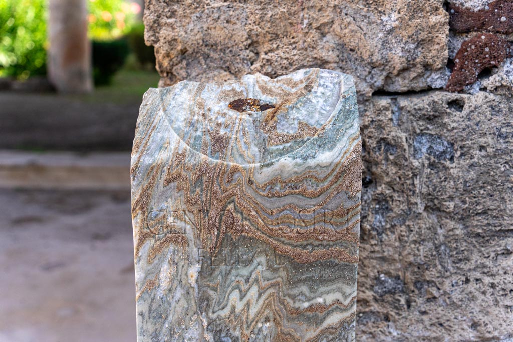 V.1.26 Pompeii. October 2023. 
Room “b”, detail of marble pillar, with wording - GENIO L NOSTRI FELIX L. Photo courtesy of Johannes Eber.