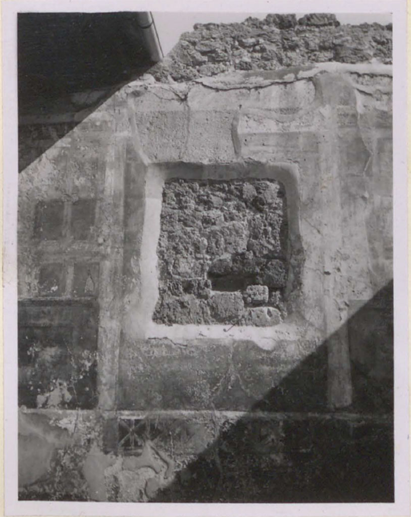 V.1.26 Pompeii. Pre-1943. Room o.
Looking towards east wall and recess remaining after the painting of Theseus abandoning Ariadne was removed and transferred to the museum. 
On either side of the recess, traces of architectural motifs can be seen.
See Warscher, T. 1942. Catalogo illustrato degli affreschi del Museo Nazionale di Napoli. Sala LXXXII. Vol.4. Rome, Swedish Institute