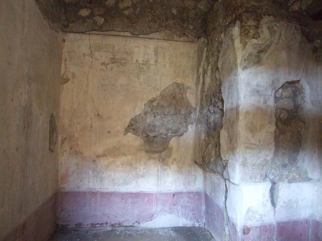 V.1.26 Pompeii. March 2009. Room "p",  north wall, and north-east corner, with purple/violet zoccolo/dado, and white middle zone.
According to PPM, the zoccolo was decorated with panels separated by narrow compartments decorated with flowers amongst palms.
In the middle of the north wall, at the rear of the alcove, Mau saw “without a cornice and on a white background, the noted group of Mars and Venus.” ………. In the side panels, seen on the left was a flying figure, on the right a standing Cupid. He could not recognise any particulars in one or other of the figures. (See Mau, BdI, 1876, p.220).
See Carratelli, G. P., 1990-2003. Pompei: Pitture e Mosaici: Vol. III. Roma: Istituto della enciclopedia italiana, (p.613, no.82).