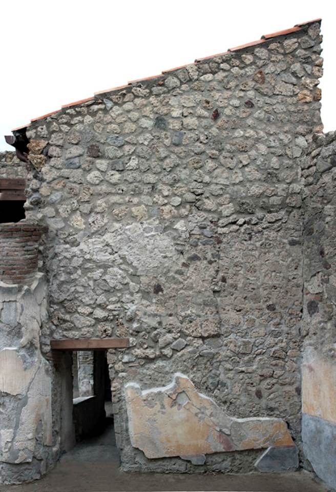 V.1.26 Pompeii. 2012? - post 2008 when room “s” was roofed.   
Room “r”, 21, north wall with doorway into room “s”. Photo by Hans Thorwid.  
Photo courtesy of The Swedish Pompeii Project.