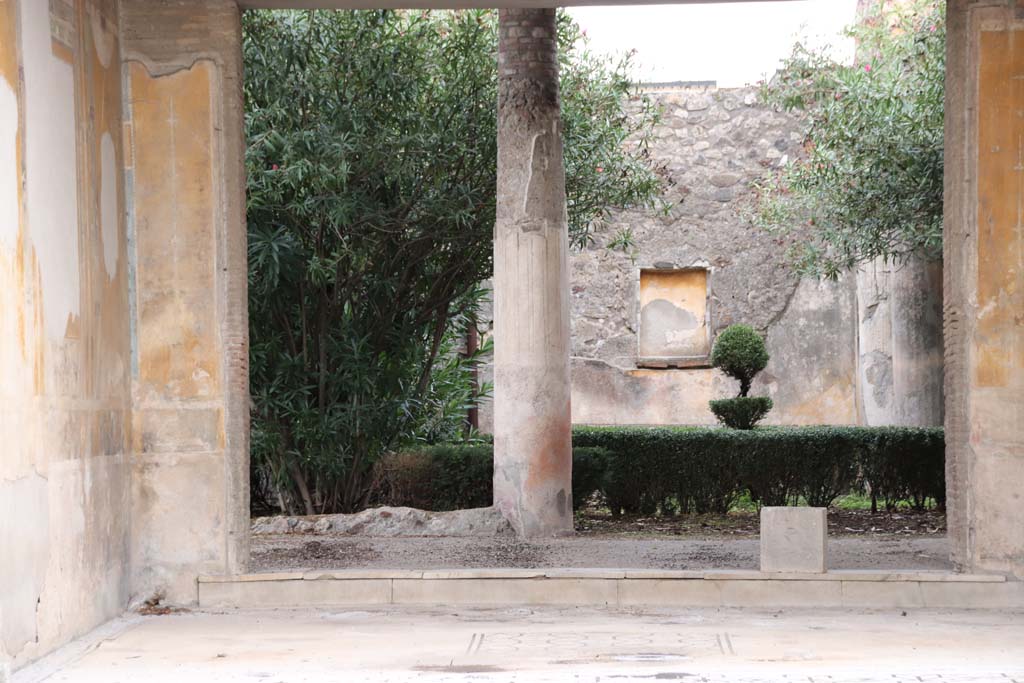 V.1.26 Pompeii. October 2020. Room i, looking east across tablinum towards step to peristyle garden. 
In the centre of the tablinum is a square mosaic emblema.
On the walls were found paintings of a Satyr and Nymph, Iphigenia in Tauris, a Maenad carrying a cupid and one possibly the Return of the Corpse Of Hector. Some of these can now be seen in the Naples Museum.
Photo courtesy of Klaus Heese.