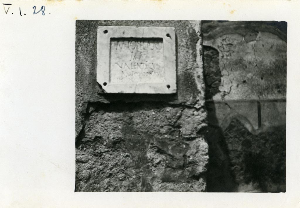 V.I.28 Pompeii. Pre-1937-39. Square stone embedded into the atrium wall.
Photo courtesy of American Academy in Rome, Photographic Archive. Warsher collection no. 653.
According to Della Corte, a bronze signet/seal was found here with the inscription C. CASSI BASSI, which proved that this house of modest proportions was lived in by C. Cassius Bassus, (see S21, with Note 1).
According to GdS, a bronze signet/seal was found here on the 28th May 1875, with the inscription C. CASSI BASSI.
See Giornale degli Scavi di Pompei, N.S.3, 1875, p. 175.
However, on the 4th June 1875, found walled into the atrium was a stone with epigraph which according to Della Corte, referred undoubtedly to the same house.
This stone slab indicated that the last owner was M. Tofelano Valente.
See Della Corte, M., 1965. Case ed Abitanti di Pompei. Napoli: Fausto Fiorentino, (p.102).