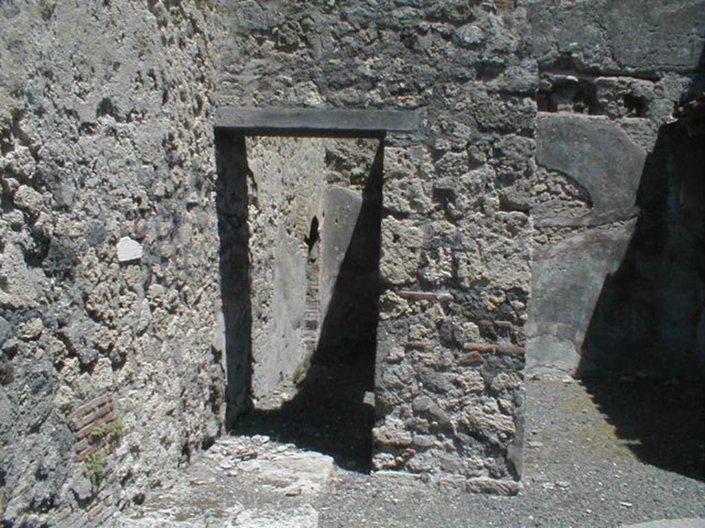 V.1.31 Pompeii. May 2005.  North side of shop, passage with vaulted latrine at rear left, and remains of base of stairs, in foreground.