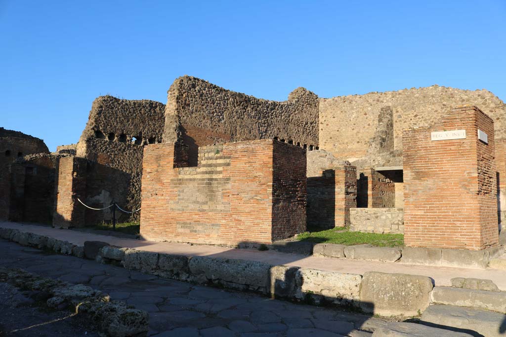 V.1.32 Pompeii, on right. December 2018. 
Looking north-east to entrance doorways on Via del Vesuvio. V.1.30, on left and V.1.31, left of centre. Photo courtesy of Aude Durand.