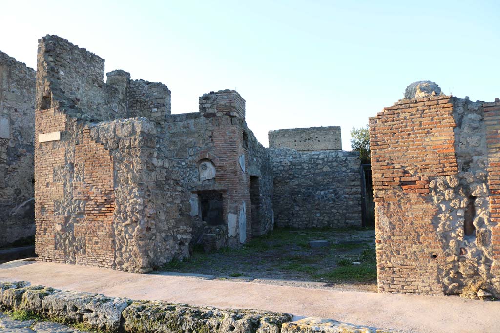 V.2.1 Pompeii. December 2018. 
Looking towards entrance doorway in south-west corner of insula on Via di Nola, with the junction of Vicolo di Cecilio Giocondo, on left. 
Photo courtesy of Aude Durand.