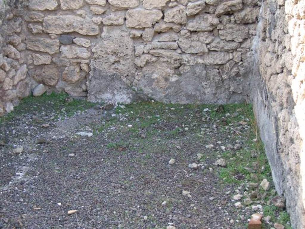 V.2.7 Pompeii. December 2007. Room 2, west ala, from doorway.
According to PPM –
Mau mentioned, but without dwelling on them for any great length (and his are the only remaining descriptions) that rooms 2, 9 and the “living room” end of 10 were all decorated in the “candelabra” style. (Mau, RM 1894, p,39-43).
See Carratelli, G. P., 1990-2003. Pompei: Pitture e Mosaici, III. Roma: Istituto della enciclopedia italiana, (p.825).
Mau wrote –
The alae, (g and h, our rooms 2 and 9) have a simple decoration on a white background, which rather recalls the "candelabra" style contemporary to the Third style.
Standing in the left ala was the capital of a Doric column in tufa, without grooves, whereby in this house there are no columns.  
There was also a large weight of lava, elliptical in shape (0.42 long): a similar weight of travertine lies in "k".
(BdI, 1894, p.40).