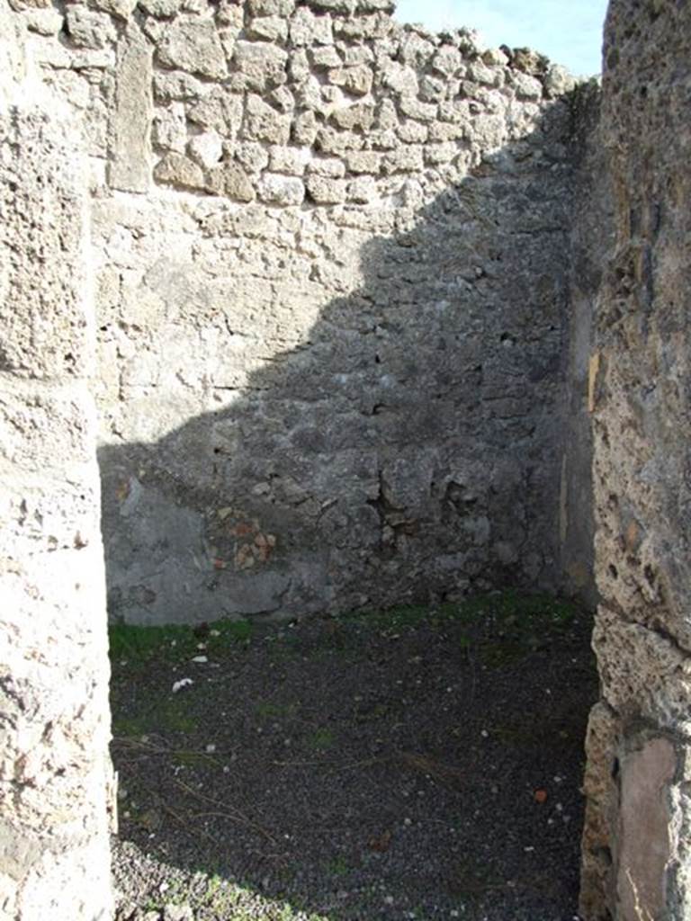 V.2.7 Pompeii. December 2007. Doorway to room 8, room on east side of atrium.
Mau wrote –
This room was a pantry, with shelves on the walls, which were covered with rough/raw plaster.
This room would have been decorated in the IV Style on a simple white background.
Found in this room was a large weight of travertine.  
In this room (8 or "k") the bed was hanging from the right wall; to enlarge the place the stucco had been removed from the relative part of the entrance and back walls (instead of making the usual recesses).
(BdI, 1894, p.40).
According to PPM, 
“On the south wall, the zoccolo was edged with a green border, the middle zone was divided into two panels with purple “carpet border” edging with rectangles divided by diagonals, separated by a yellow border.”