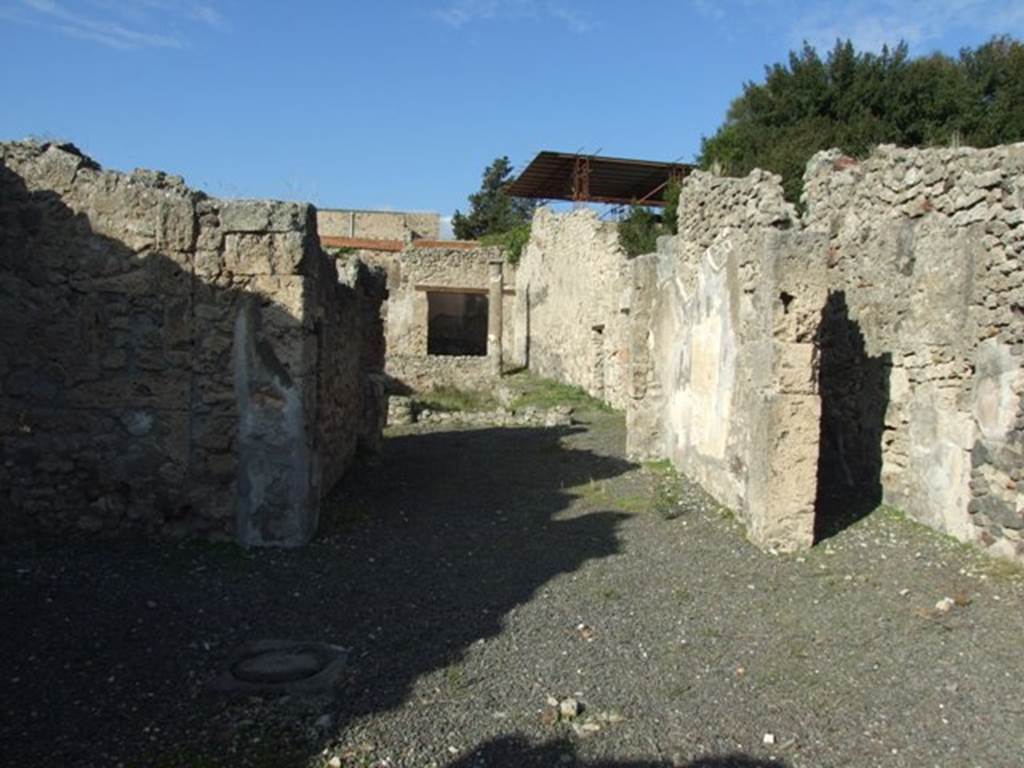 V.2.10 Pompeii. December 2007. Looking north towards room 3, tablinum.
According to NdS, opposite to the entrance corridor was the tablinum, with the doorframes covered in fluted white plaster.
On the east wall was the painting of Hippolytus and Phaedra, described in NdS and BdI.
See Notizie degli Scavi di Antichità, 1891, (p.268). 
According to BdI, the tablinum was painted in the “style of the candelabra” but was only preserved on the right (east) wall. In the middle of the wall between two thin green candelabra a white panel was left (1.50 high x 0.91 length). It showed Hippolytus and Phaedra, occupying nearly the entire width but was not higher than 0.80.
On the same wall, on the upper part to the left, (0.54 high x 0.42 length) but badly preserved was a painting with doors, in the usual manner. On the left, was a clothed woman playing the lyre which she held on her left side.
To the right of the centre, another fully-clothed woman (looking left) leaning against a column, raises her left hand, in which she holds an object in the guise of a roll(?) (un rotolo) and whose other extremity, seems to touch the chin. Further to the right up to the border, but further back, stands a building, open in front and back, in which you recognize a figure whose details are not distinguished: it seems, however, that she is naked and that she is putting a cloth on top of some furniture.
See Mitteilungen des Kaiserlich Deutschen Archaeologischen Instituts, Roemische Abtheilung Volume XXVI, 1890, p. 260-261).