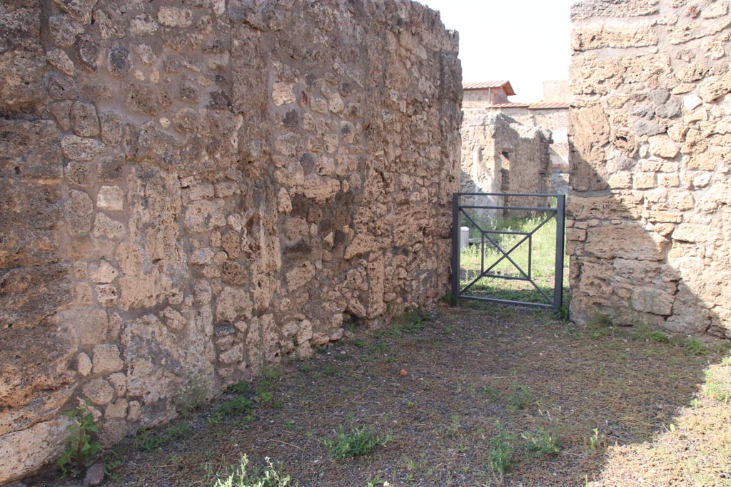 V.2.11 Pompeii. October 2023. 
Looking north along west wall of shop-room, towards doorway into V.2.10 in north-west corner. Photo courtesy of Klaus Heese.