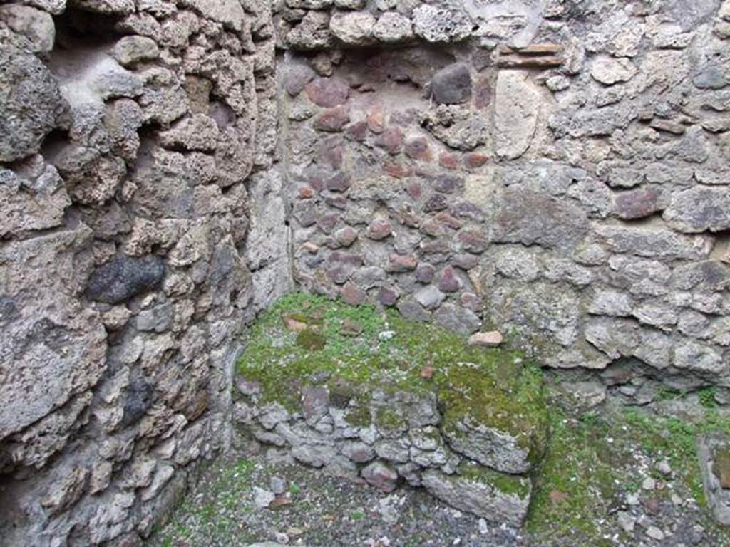 V.2.13 Pompeii. March 2009. Kitchen with hearth in north-west corner.
According to Boyce, above the hearth was a badly preserved lararium painting. The Genius was represented sacrificing at an altar. On each side stood a Lar, but only the one on the right was preserved. Further to the right a serpent approached an altar. The description was from Sogliano published in 1879. Reports in periodicals published in 1894 and 1896 mention only an altar as being visible in a painting.  Today, nothing remains.
See Boyce G. K., 1937. Corpus of the Lararia of Pompeii. Rome: MAAR 14. (No. 92 on p34)
See Sogliano, A., 1879. Le pitture murali campane scoverte negli anni 1867-1879, Naples.