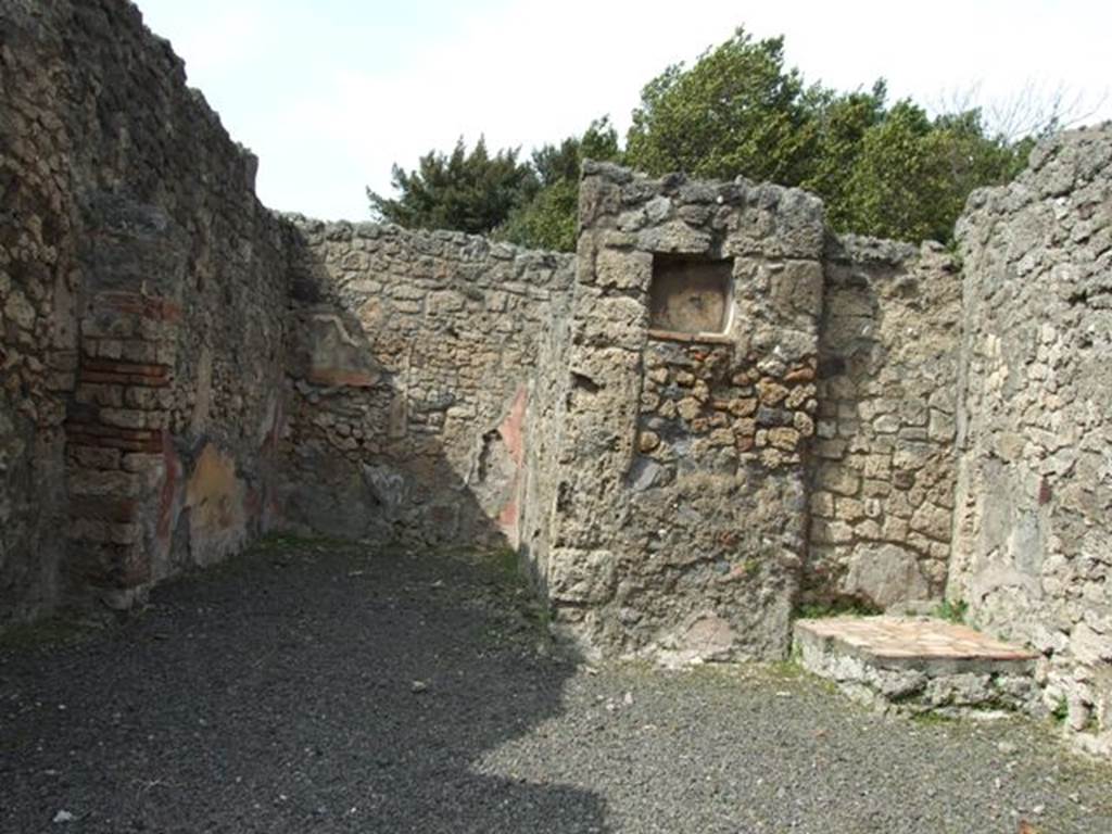 V.2.14 Pompeii. March 2009. North wall, with rear room, lararium and base for stairs.
According to NdS, this shop had the remains of painted decoration with a white background.
In the north wall was the lararium niche, coated with plaster.
The rear room was decorated with red and yellow panels, and contained a painting in each of the yellow panels on the north and east walls.
One represented the departure of Chryseis, (or Helen, see below) and the other Ulysses and Circe.
See Notizie degli Scavi di Antichità, 1891, p. 270-1 for description of paintings.
Seen in the red side panels, were flying cupids with various attributes.
See Notizie degli Scavi di Antichità, 1896, (p. 438).