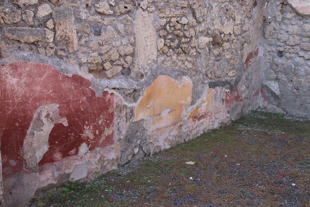 V.2.14 Pompeii. October 2022. 
West wall of rear room with remains of yellow central panel, and the two red side panels. Photo courtesy of Klaus Heese.