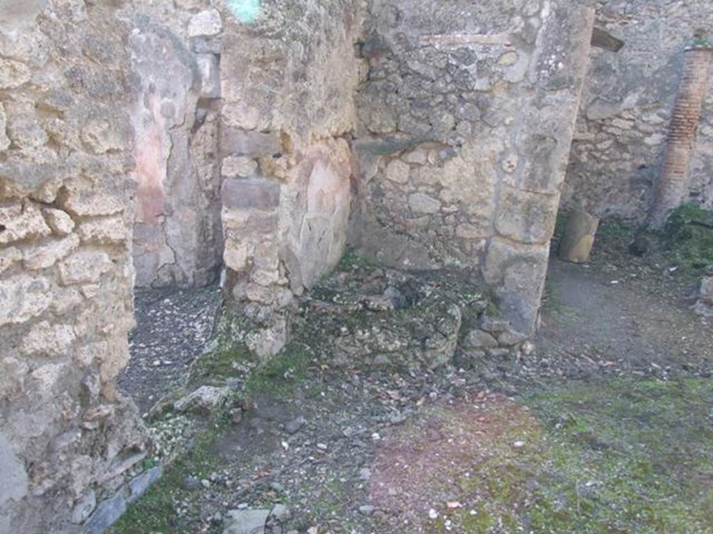V.2.15 Pompeii. December 2007. Remains of circular stone feature in south-west corner of peristyle. On the left is the wall with window in north wall of room 4, overlooking peristyle.