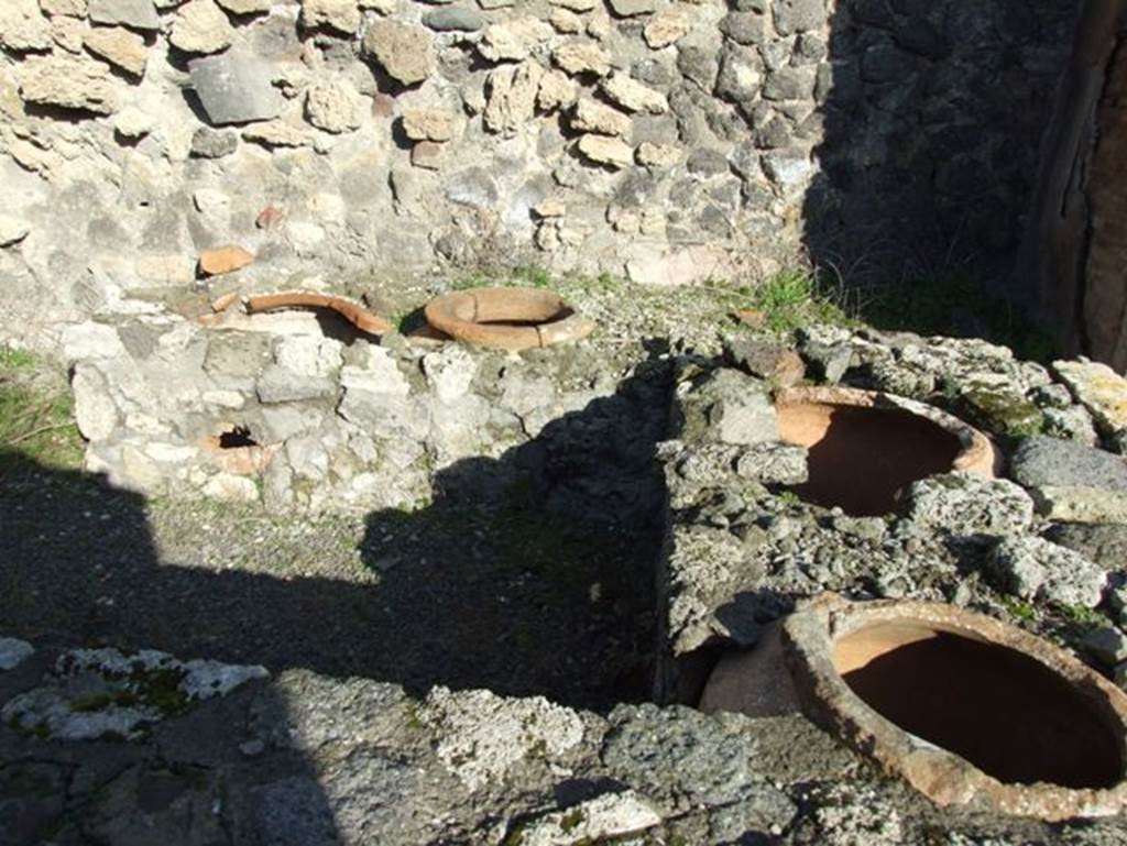 V.2.19 Pompeii. December 2007. Looking east across three-sided counter with remains of four urns and hearth.