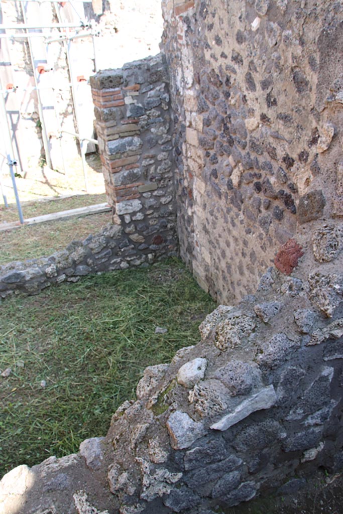 V.2.19 Pompeii. October 2022. 
Looking towards south-east corner of small room, with window into rear room.
Photo courtesy of Klaus Heese.