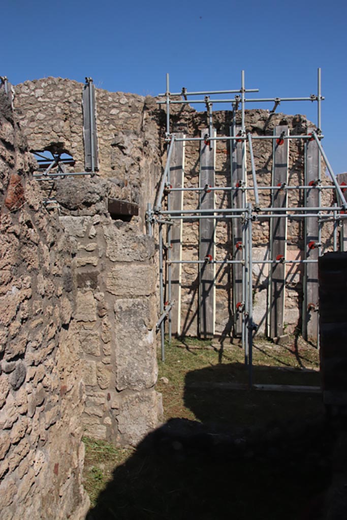 V.2.19 Pompeii. October 2022. 
Looking towards north-east corner of small room, with window into rear room, (taken from V.2.17).
The doorway from V.2.20 is on the left.  Photo courtesy of Klaus Heese.