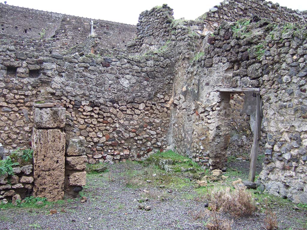 V.2.f, Pompeii. December 2005. Looking south-east across atrium. On the left would have been a cubiculum.
In the centre can be seen a room with remains of three masonry steps to an upper room above the cubiculum, and doorway to a small courtyard. 
According to NdS, on the black dado of the room with the stairs was a graffito – MID/
See Notizie degli Scavi di Antichità, 1896, (p.436).
See Mau in Bullettino dell’Instituto di Corrispondenza Archeologica (DAIR), VIII, 1893, (p.7-9)
According to Jashemski, a terracotta dolium and several amphorae were found in the courtyard.
See Jashemski, W. F., 1993. The Gardens of Pompeii, Volume II: Appendices. New York: Caratzas, (p.112)