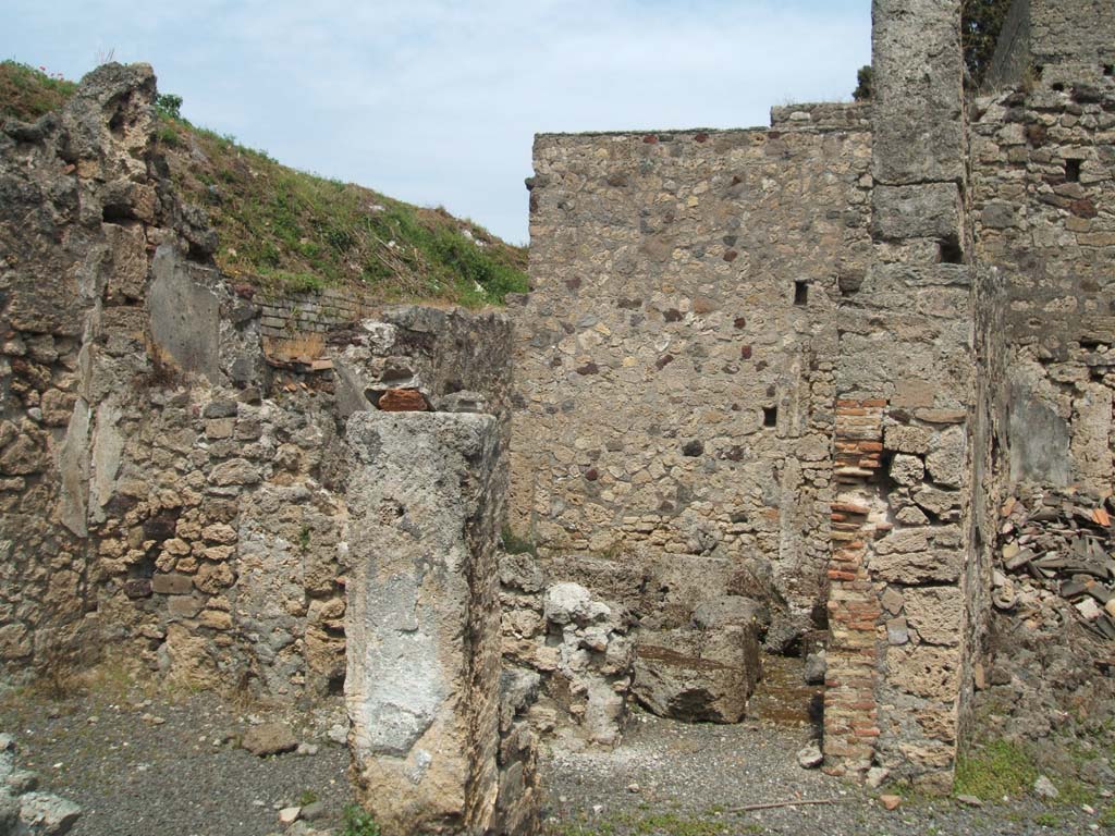 V.2.g Pompeii. May 2005. Looking across western doorway of room ‘c’ including pillar in the middle of the two doorways, on left. 
The doorway to room ‘d’ in the north-east corner of atrium, can be seen in the centre.
Part of the doorway to room ‘g’ can be seen on the right.