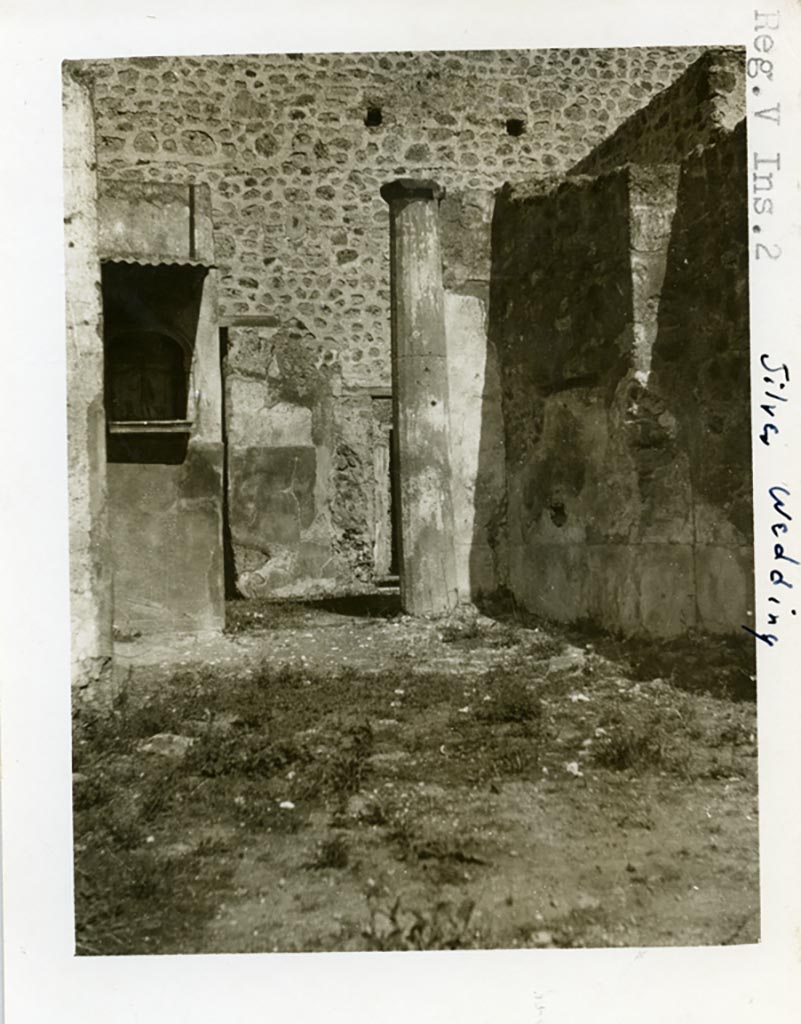 V.2.h Pompeii but shown as from “Silver Wedding” (V.2.i) on photo. Pre 1937-39.
Looking north across garden area towards north wall with lararium with painting of Hercules, and column.
Photo courtesy of American Academy in Rome, Photographic Archive. Warsher collection no. 1575.