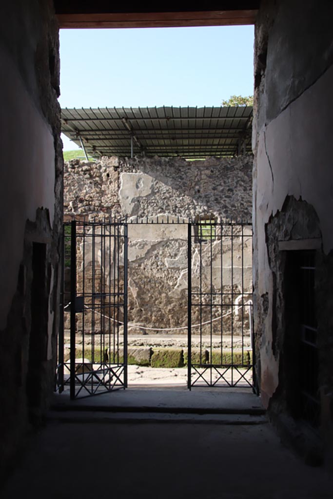 V.2.i Pompeii.  October 2023. 
Looking north through entrance doorway onto Vicolo delle Nozze d’Argento.  
Photo courtesy of Klaus Heese.