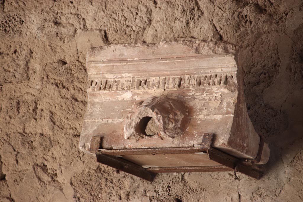 V.2.i Pompeii. October 2023. Grondaia or water-spout displayed on west wall of tablinum 7. Photo courtesy of Klaus Heese.
Originally would have been set around the four sides of the compluvium, above the impluvium in the atrium.  
The rainwater would have been channelled to pour through the open mouth of the lion into the impluvium below.