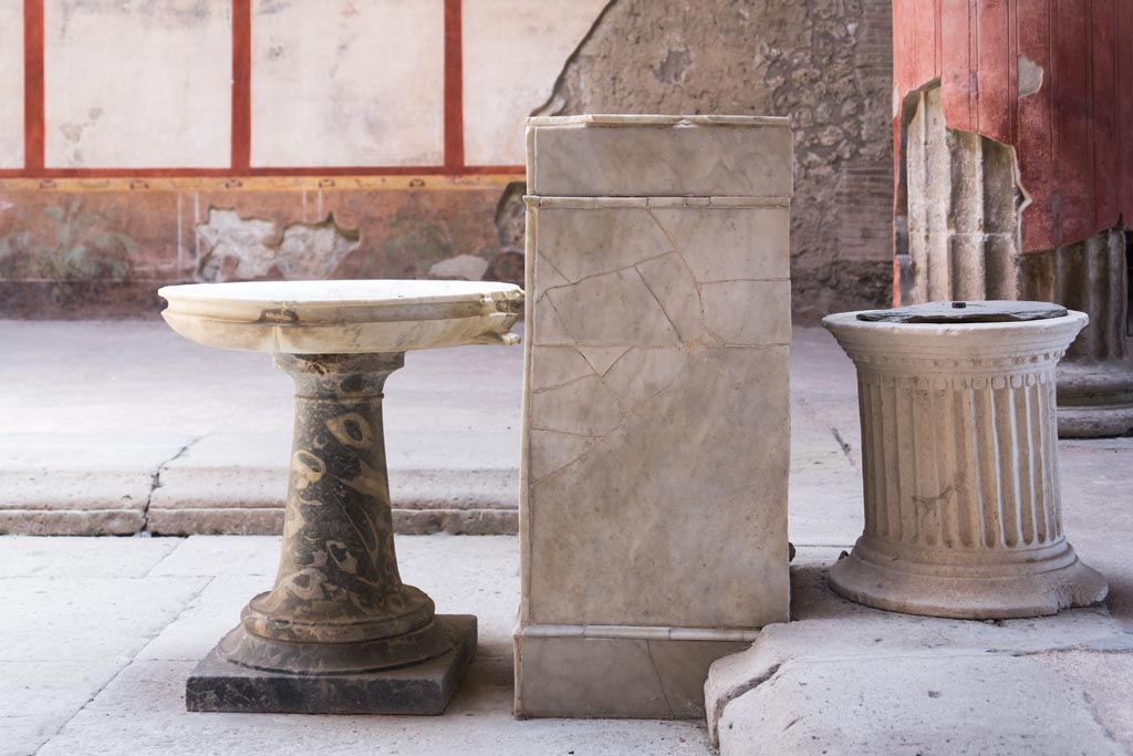 V.2.i Pompeii. August 2023. Room 1, atrium, south end of impluvium. 
Looking east towards stone basin on stand, rectangular marble base and travertine puteal. Photo courtesy of Johannes Eber.