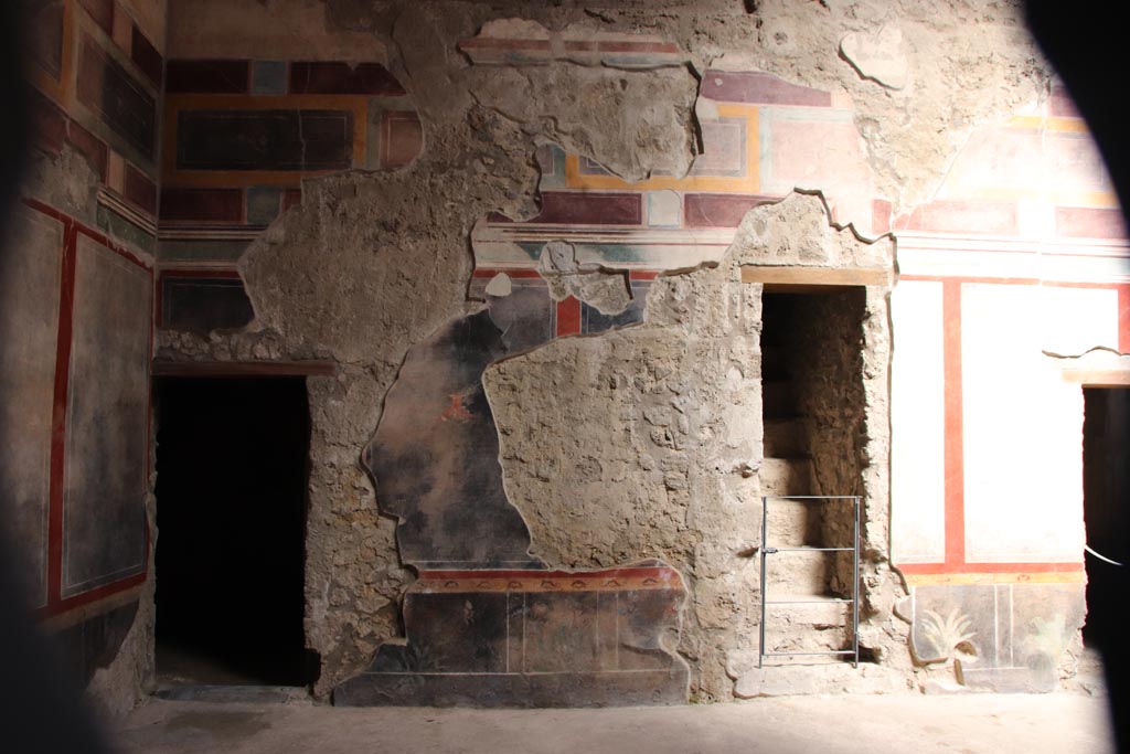 V.2.i Pompeii.  October 2023. 
Room 1, east wall of atrium at north end, room 3, on left, and stone staircase, centre right. Photo courtesy of Klaus Heese.
