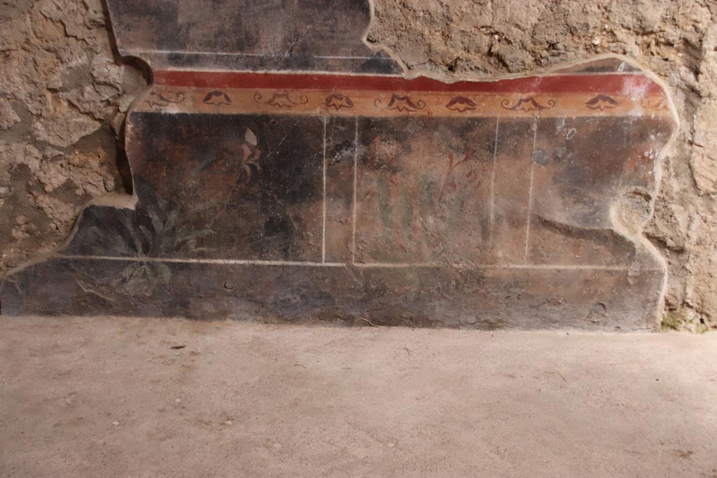 V.2.i Pompeii.  October 2023. 
Room 1, east wall of atrium, painted zoccolo between room 3 and stone staircase. Photo courtesy of Klaus Heese.