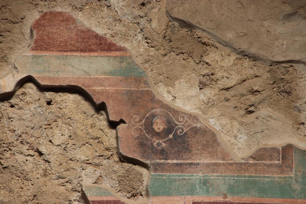 V.2.i Pompeii.  October 2023. 
Room 1, upper east wall on south side of doorway to room 4, detail of fragment of painted panel. Photo courtesy of Klaus Heese.