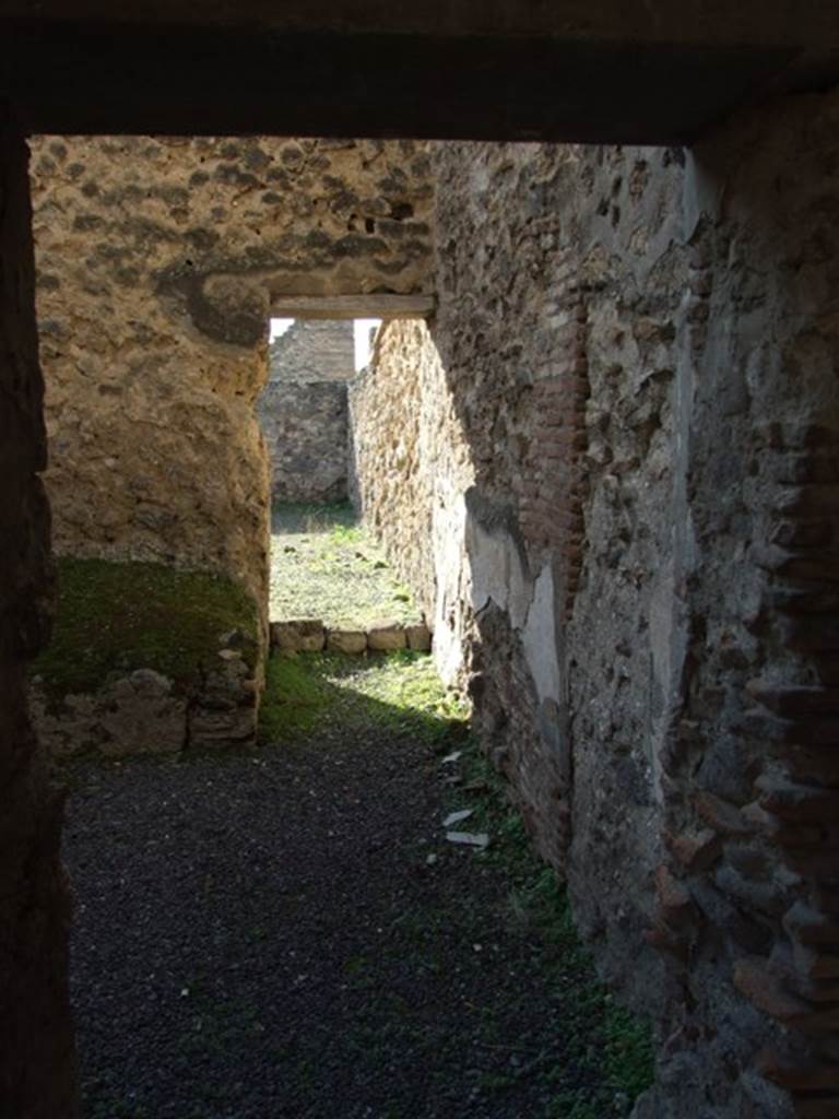 V.2.i Pompeii. December 2007. Doorway to room 11, kitchen. Looking west from peristyle through kitchen to garden area.
.