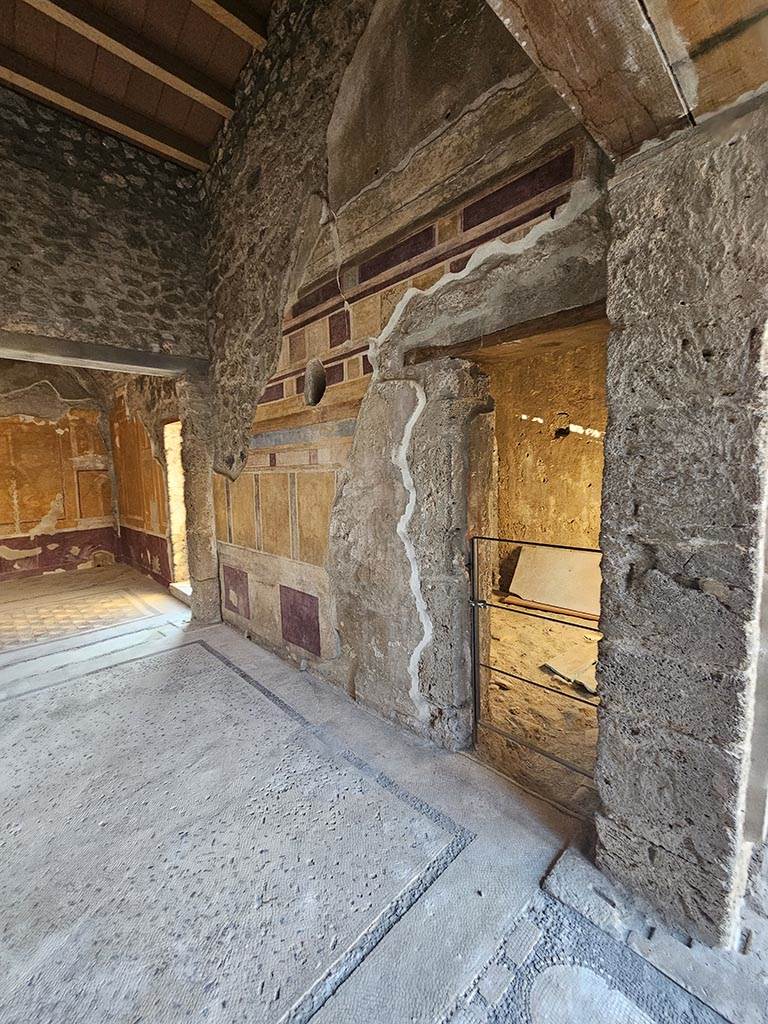 V.2.i Pompeii. November 2024.
Room 14, north wall of antecamera, with doorway to tepidarium room 15, on right. 
The door at the west end of the north wall leads into the garden area. Photo courtesy of Annette Haug.