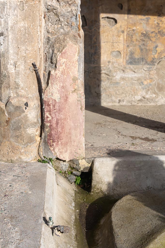 V.2.i Pompeii. January 2024. 
Looking east in north-east corner of peristyle, with tap and pipe attached to column/pilaster. 
Photo courtesy of Johannes Eber.