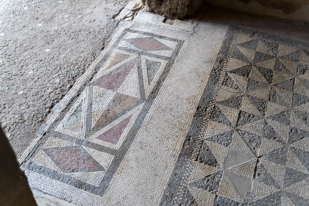 V.2.i Pompeii. March 2023. 
Room 18, detail of mosaic doorway threshold, on left, and mosaic flooring, on right. Photo courtesy of Johannes Eber.