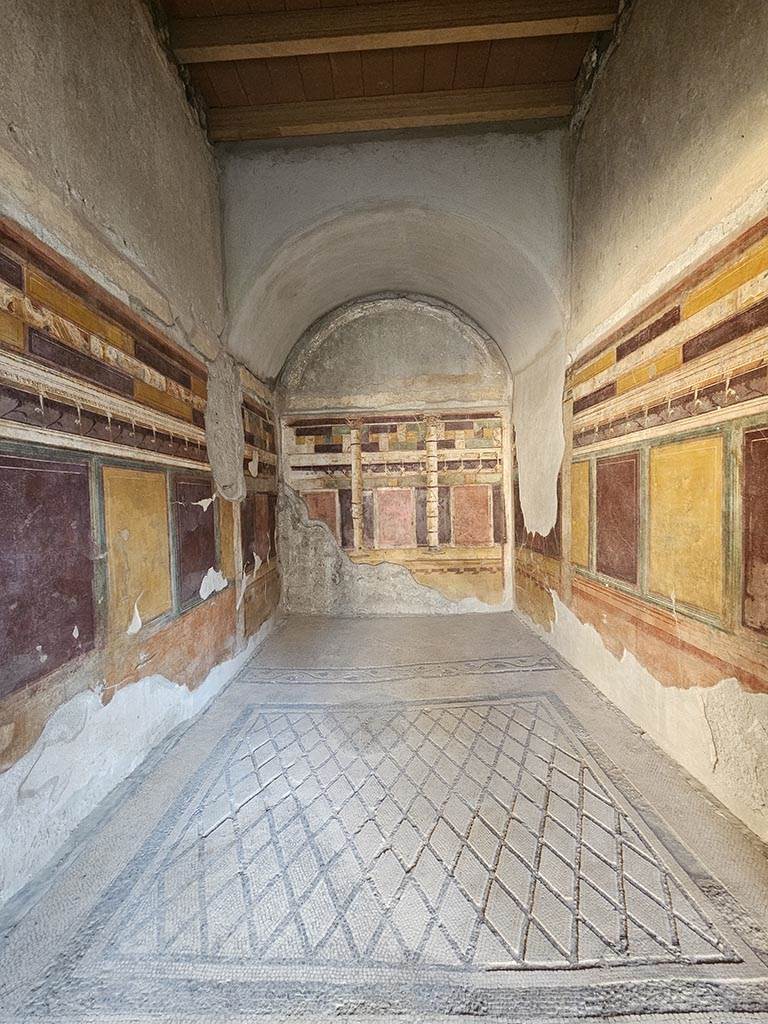 V.2.i Pompeii. November 2024. 
Room 20, looking south across mosaic flooring towards rear area for a couch. Photo courtesy of Annette Haug.