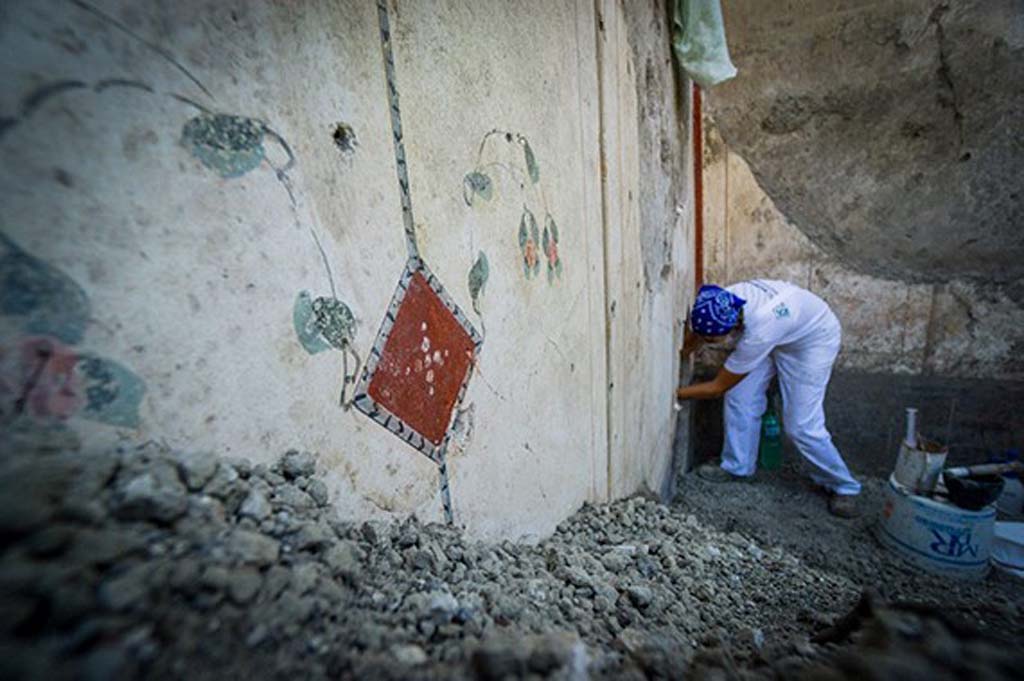 V.2.15 Pompeii. August 2018. Room A13 with white walls with a floral design. In the corner is a hole in the wall created by the Bourbon tunnellers.
Photograph © Parco Archeologico di Pompei.