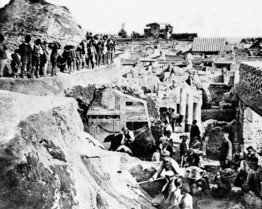 V.2 Pompeii. Casa di Orione. Late 19th century photograph showing excavation, (c.1896).
Looking south from south-east corner of V.2.i, across the columns in the peristyle garden of Casa di Orione/V.2.15 Casa di Giove, towards the rear of the Casina dell’Aquila in the distance. 
In the centre front, the second style decoration on south wall of Corinthian oecus, room 21 of The House of the Silver Wedding at V.2.i can be seen.
Photo courtesy of Rick Bauer.