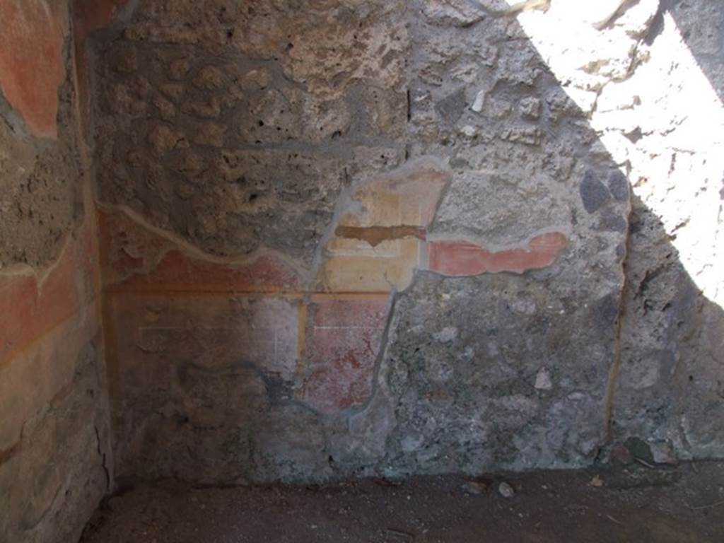 V.3.4 Pompeii. March 2009. Front room on east side of tablinum. North-west corner and north wall. According to Sogliano, this room was covered by a barrel-vaulted roof, and had a window overlooking the garden area and its floor was of opus signinum. Fragments of marble slabs were scattered in the opus signinum, and in the centre was a kind of star enclosed in a panel, both made from small dark marble tesserae. The plastered walls were covered with large red panels divided by large yellow stripes or pilasters, with a white frieze.
The base of the wall was divided into alternate black and red panels. See Notizie degli Scavi di Antichità, 1905, (p.208)