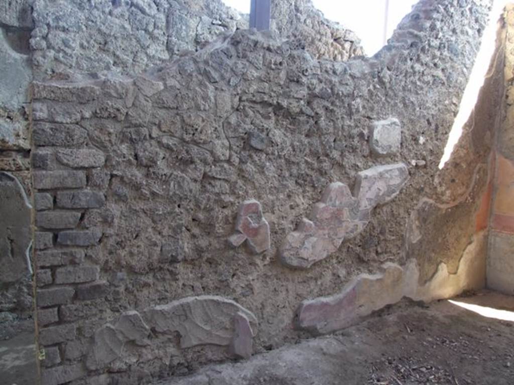 V.3.6 Pompeii. March 2009. Triclinium, east wall.
According to NdS, 
“The facing east wall (from the west wall) had suffered most of all. 
Only the lower part remained of the central painting, which consisted of the legs of a figure clothed in a violet robe, sitting on a noble marble rostrum whose feet were formed to look like flying griffins. On the ground, leaning against the rostrum, was a lyre with ten chords. Behind the seated figure was a standing female figure in a white robe, but only the legs remained.”
See Notizie degli Scavi, 1902, p.566.
