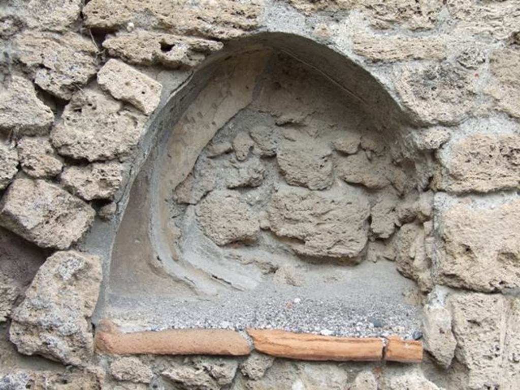 V.3.8 Pompeii. December 2007. Niche in north wall of atrium. According to Boyce, the last coating of stucco had fallen away, revealing beneath it an earlier one. This was a yellow rear wall decorated with red spots and solid red side walls. See Boyce G. K., 1937. Corpus of the Lararia of Pompeii. Rome: MAAR 14. (p.39, no.113)