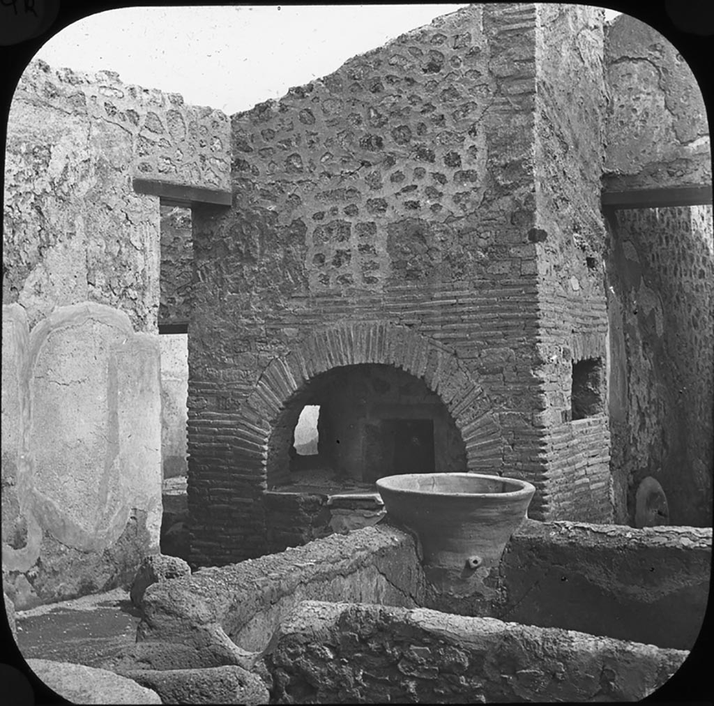 V.3.8 Pompeii. Looking south-east across bakery towards oven. 
Photo by permission of the Institute of Archaeology, University of Oxford. File name instarchbx202im 062. Source ID. 44551
See photo on University of Oxford HEIR database