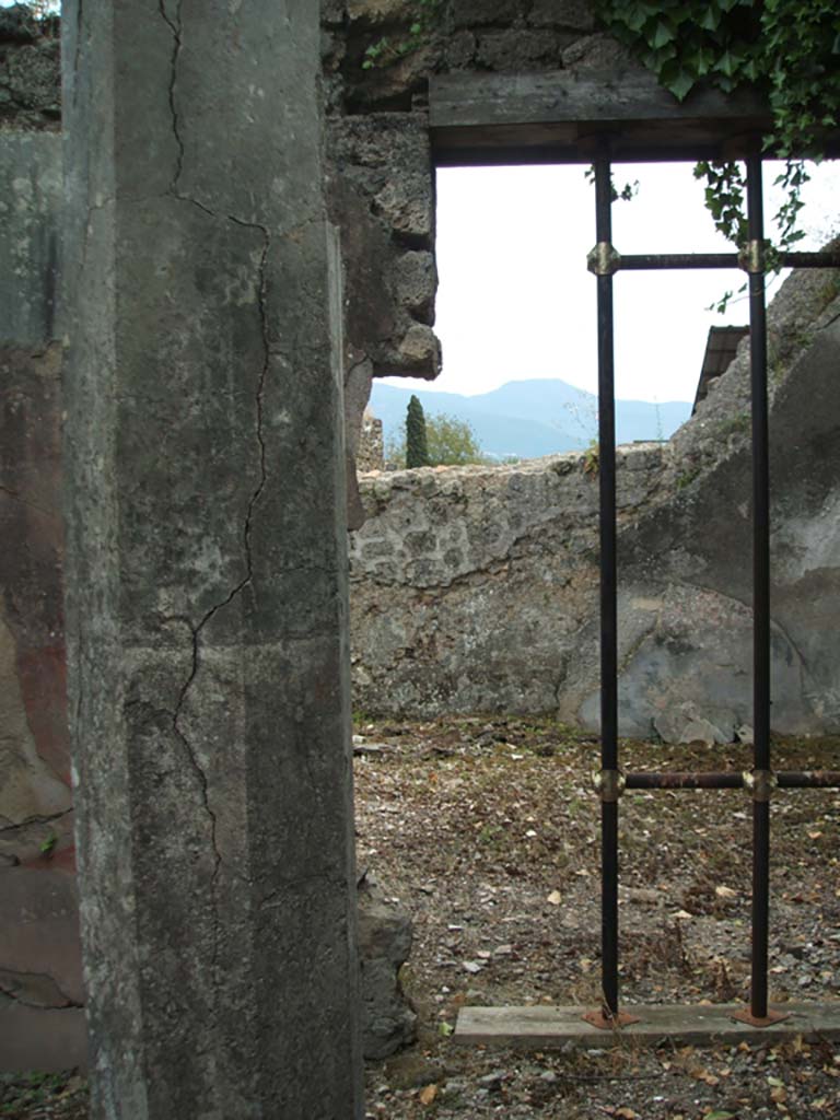 V.3.10 Pompeii. May 2005. South side of south portico of garden area.  
Eight-sided column, originally painted red, supporting the south portico.
In the background, the doorway to large triclinium.