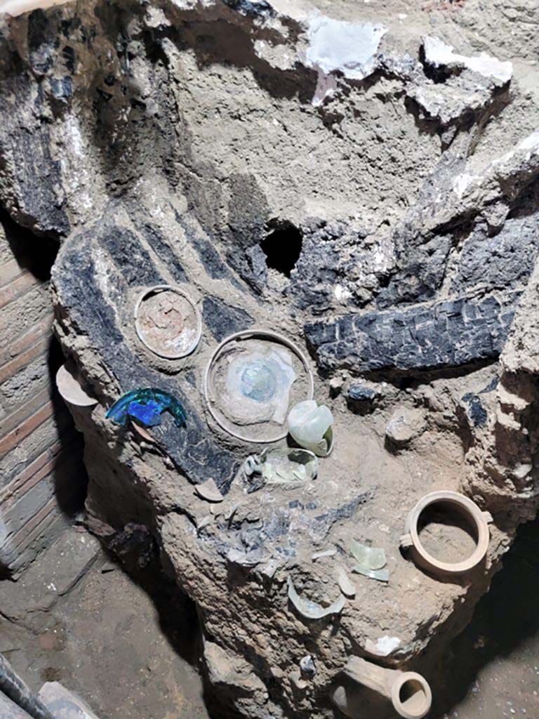V.3.13 Pompeii. 2022. Room 2b. Remains of wooden cabinet.
On the highest shelf, small jugs and amphorae, as well as glass plates, have been found. 
Resti di armadio in legno.
Sul ripiano più alto sono state rinvenute piccole brocche e anfore, oltre a lastre di vetro.
Photograph © Parco Archeologico di Pompei.