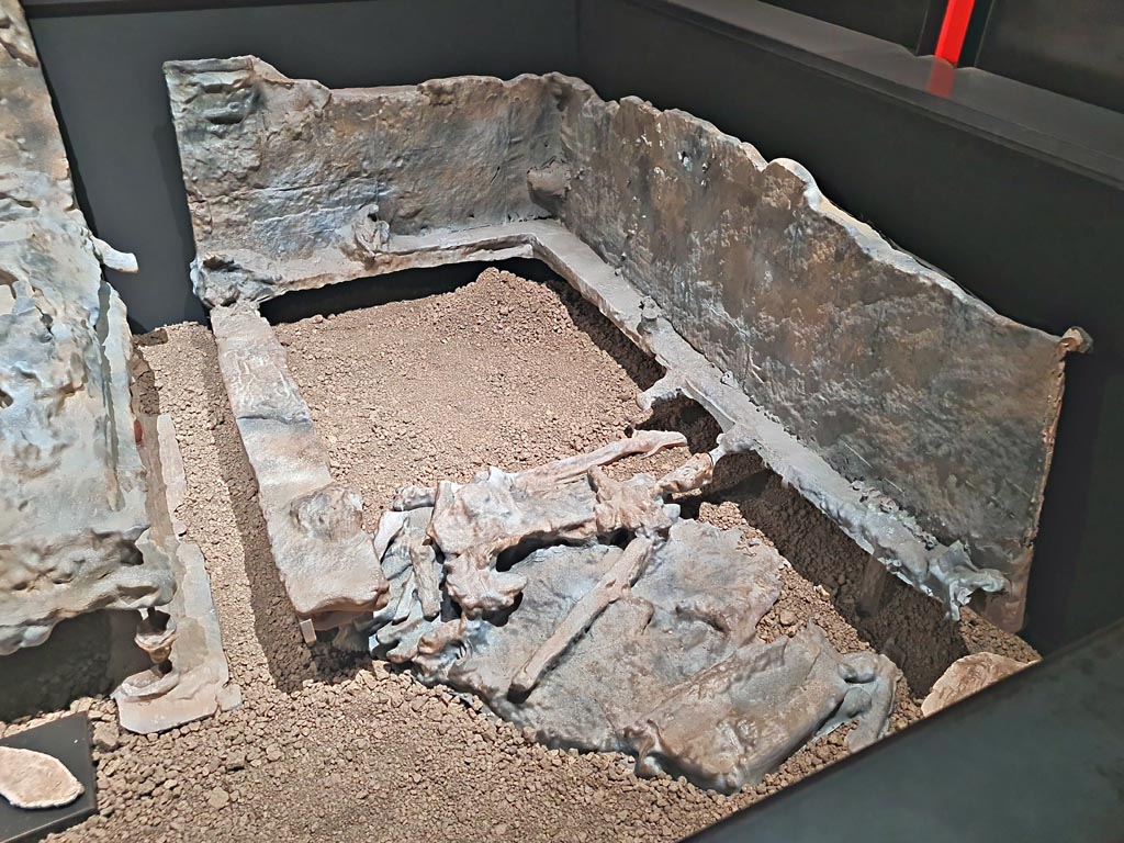 V.3.14 Pompeii. March 2024. 
Room 16, casts of bed 2, letto 2 on the plan, and the furnishings (the bed is a copy, while the sole of the shoe, lower left, is original.) 
On display in exhibition in Palaestra entitled “L’altra Pompei, vite comuni all’ombra del Vesuvio”. Photo courtesy of Giuseppe Ciaramella.