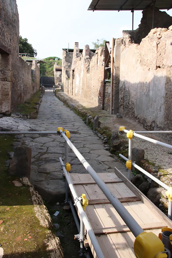 Vicolo dei Balconi, Pompeii. October 2022. 
Looking north along roadway between V.2, on left, and V.3, B5 to B1, on right. Photo courtesy of Klaus Heese.